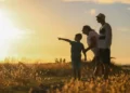 A family out in a field at sunset