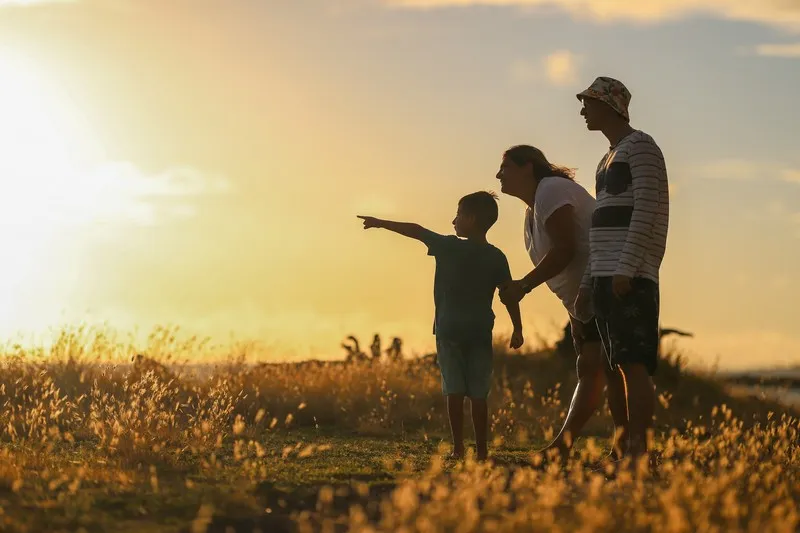 A family out in a field at sunset