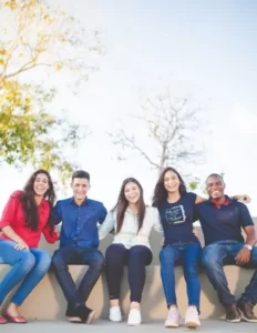 A group of friends sat on a wall on a sunny day expressing solidarity