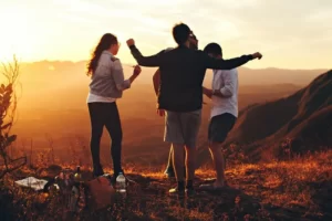 A group of friends on a mountaintop at sunset