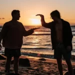two guys high fiving at sunset