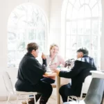 Some friends ahving a coffee in a cafe in front of bright windows on a sunny day