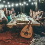 Friends and family sitting around an outside table at night