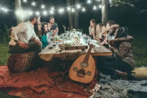 Friends and family sitting around an outside table at night