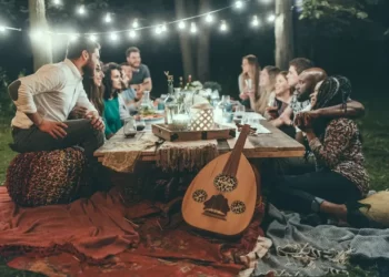Friends and family sitting around an outside table at night