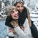 Two females hugging and laughing in the snow