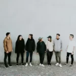 A group involved in community safety standing against a wall