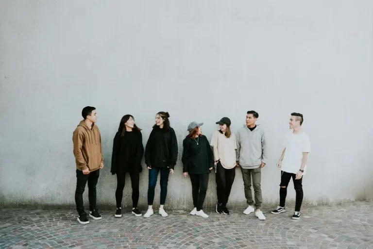 A group involved in community safety standing against a wall