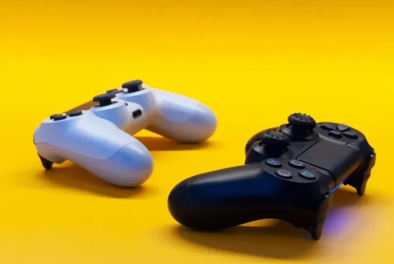 two playstation controllers against a yellow background