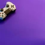 A PS4 controller against a purple hued background.