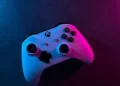 A white xbox controller under purple and pink lighting