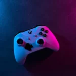 A white xbox controller under purple and pink lighting