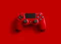 A red playstation 4 controller in red set against a red background