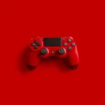 A red playstation 4 controller in red set against a red background