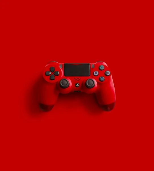 A red playstation 4 controller in red set against a red background