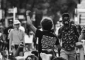 black and white rearview shot of revolution protestor raising fist in the air