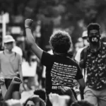 black and white rearview shot of revolution protestor raising fist in the air