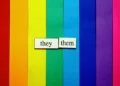 a raindbow background with the words 'they/them'.