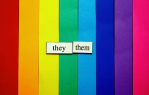a raindbow background with the words 'they/them'.