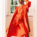 an androgynous person in orange clothing