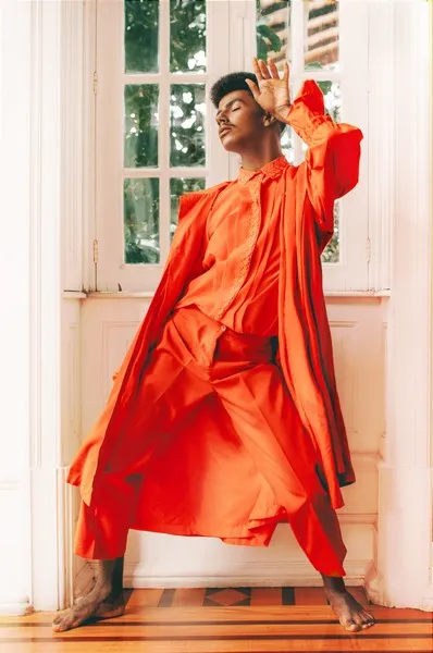 an androgynous person in orange clothing