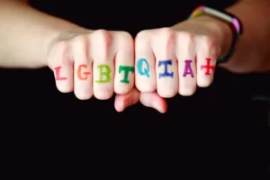a persons's fists with the letters LGBTQIA+