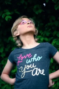 A person wearing a t-shirt with an identity slogan saying 'love who you are'