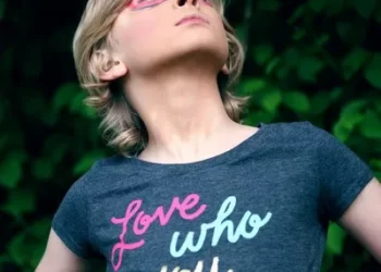 A person wearing a t-shirt with an identity slogan saying 'love who you are'