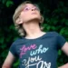 A person wearing a t-shirt with an identity slogan saying 'love who you are'