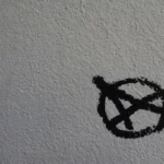 An anarchist symbol written in black on a white background
