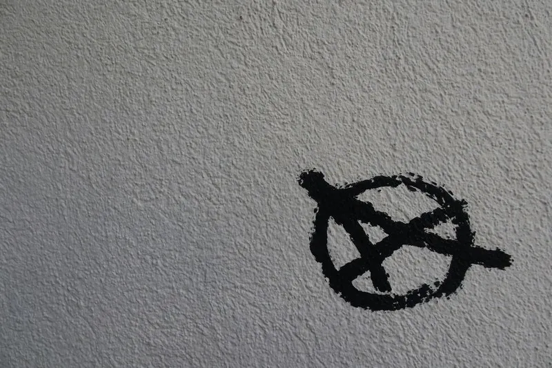 An anarchist symbol written in black on a white background