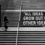 a grey shot of a person climbing stairs with the words 'all ideas grow out of other ideas'