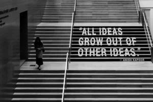 a grey shot of a person climbing stairs with the words 'all ideas grow out of other ideas'