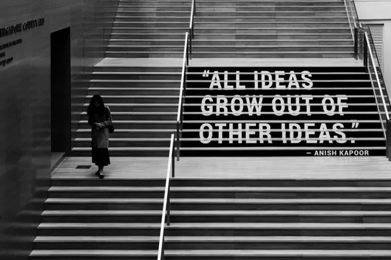 a grey shot of a person climbing stairs with the words 'all ideas grow out of other ideas'