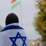 A person draped in the Israeli zionist star of david flag