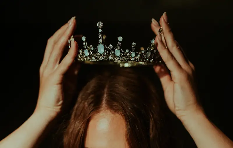 A woman adorning a crown - ascribed status