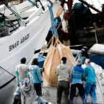 A group of men working in shipping