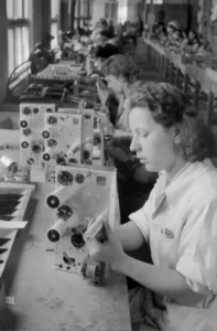 Women assembling technology items in the 1950's using the forces of production