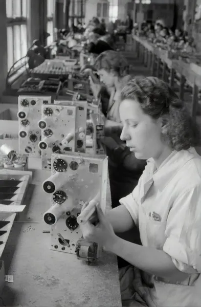 Women assembling technology items in the 1950's using the forces of production