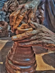a person with workplace worn hands covered in thick clay