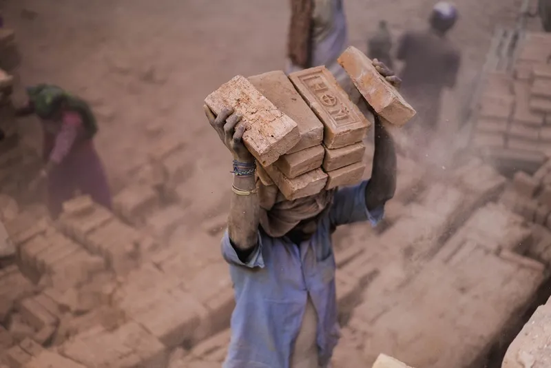 A man carrying a large pile of bricks