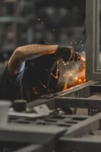 A person welding in a factory as human capital