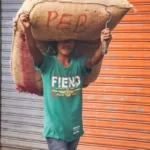 A man carrying a large sack of grain