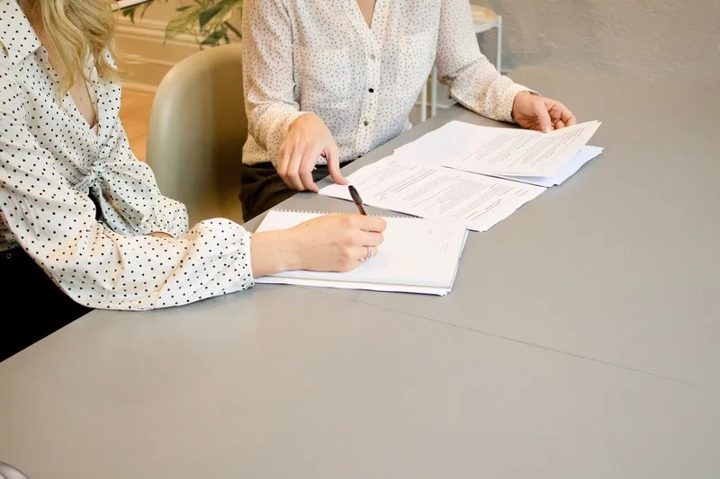Two people sigining a contract