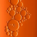 Various sized bubbles against an orange background - atomism