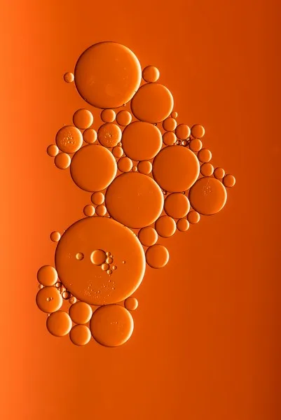 Various sized bubbles against an orange background - atomism