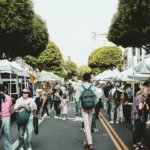 An open air market with people walking in the road