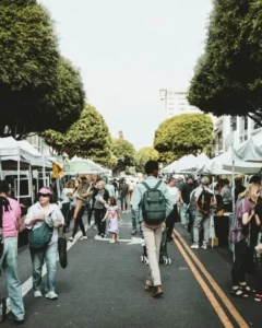 An open air market with people walking in the road