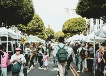 An open air market with people walking in the road