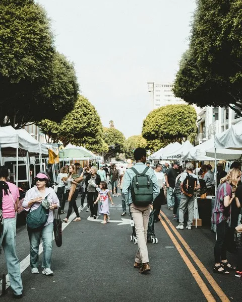 An open air market with people walking in the road